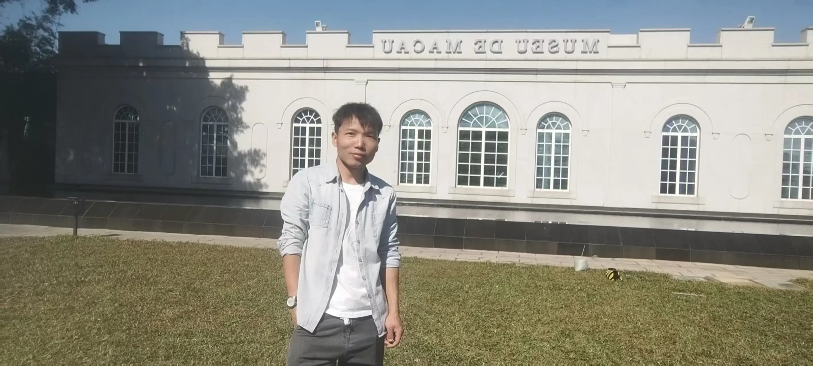 YangSir, founder of Yard Gear Hub, standing outside a hotel in Macau, casual portrait with a genuine smile, authentic real-life photo representing the person behind the gardening and composting content blog.
